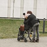 Duas pessoas abraçadas, sendo uma um cadeirante.