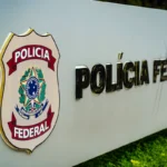 Um muro com o símbolo e o nome Polícia Federal