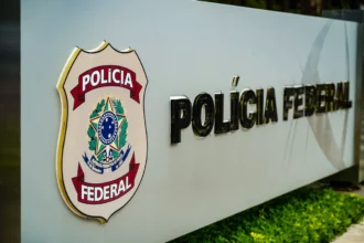 Um muro com o símbolo e o nome Polícia Federal