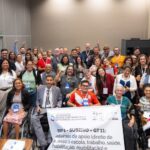 Grupo diverso de pessoas, incluindo pessoas com deficiência e usuários de cadeira de rodas, posa sorridente para a foto durante o 5º Fórum Nacional dos Direitos da Pessoa com Deficiência, realizado em Brasília, de 14 a 17 de julho de 2024. Ao centro, uma faixa destaca o tema do grupo de trabalho: “Sistemas de apoio – direito de acesso à escola, trabalho, saúde, habilitação, reabilitação”.