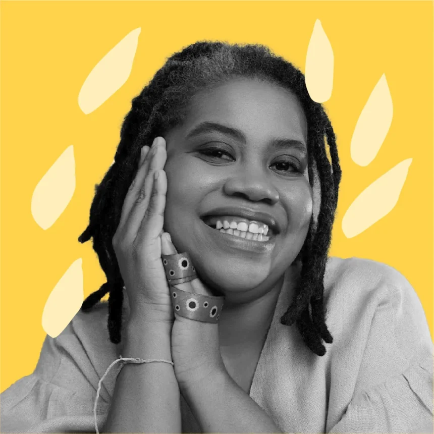 Luciana Viegas, sorrindo e apoiando o rosto nas mãos. Ela veste uma blusa clara e está em frente a um fundo amarelo com formas orgânicas decorativas.