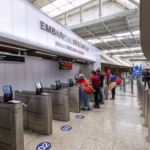 Grupo de pessoas na fila de um balcão de aeroporto.