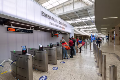 Grupo de pessoas na fila de um balcão de aeroporto.