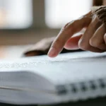 Mão sobre um livro em braile