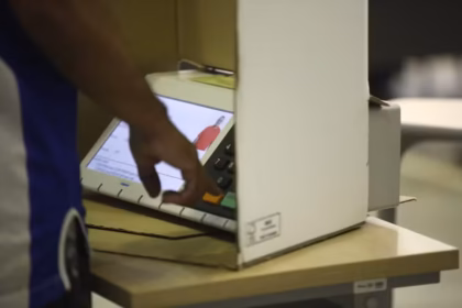 Pessoa utilizando uma urna eletrônica durante votação.