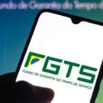 Smartphone exibindo o logotipo do FGTS (Fundo de Garantia do Tempo de Serviço) com detalhes nas cores verde, amarelo e branco.