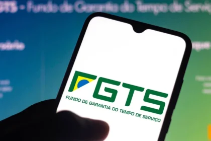 Smartphone exibindo o logotipo do FGTS (Fundo de Garantia do Tempo de Serviço) com detalhes nas cores verde, amarelo e branco.